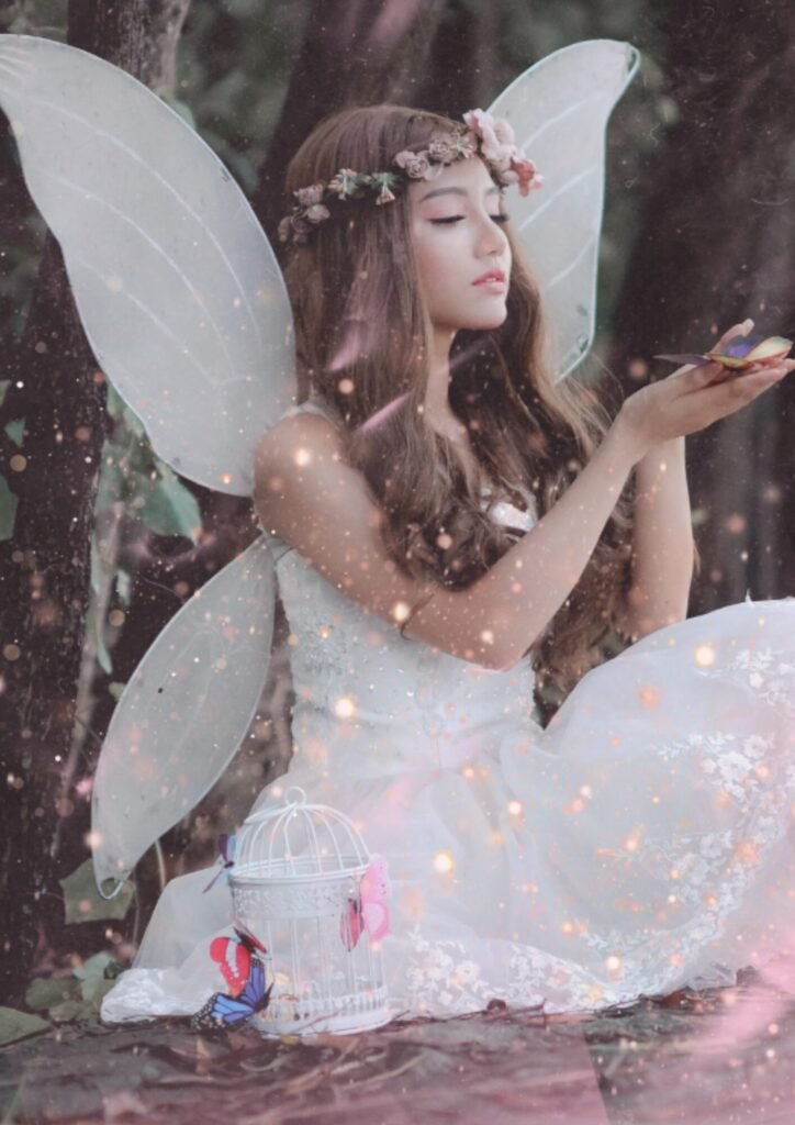 A fairy-tale inspired figure in a white dress holds colorful butterflies, surrounded by enchanting foliage and a delicate birdcage.